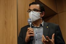 Fotografía del candidato a la presidencia, José María Villalta, con mascarilla, hablandoa través de un micrófono en la mano.
