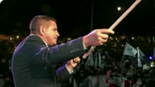 Fotografía de Carlos Alvarado hablando con micrófono en mano.