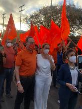 Fotografía del candidato presidencial Eliécer Feinzaig, en compañia de su esposa Rosi Weisman, alrededor de diversos votantes con banderas de su partido.