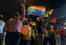 Fotografía de personas sosteniendo banderas de la diversidad sexual