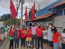 Fotografía del candidato presidencial Jhonn Vega compartiendo con votantes con camisas y banderas de su partido.