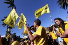 Fotografía de personas partidarias del Frente Amplio, con camisas y banderas.