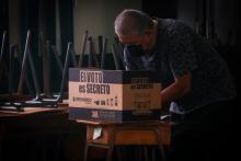 Fotografía de un hombre emitiendo su voto.