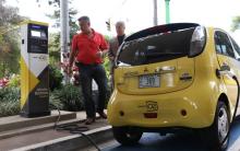 Fotografía de una persona cargando un automóvil eléctrico. 