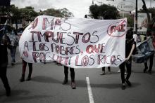 Fotografía de un conjunto de personas caminando en una carretera, en una marcha.