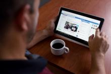 Fotografía de una persona interactuando en redes sociales, a través de una tablet.