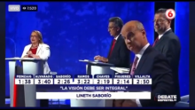 Fotografía del Debate de Repretel, donde se observa a la candidata presidencial Lineth Saborío mientras el candidato José María Figueres presenta rostros de desaprobación y burla.