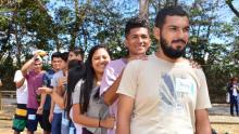 Fotografía de jóvenes haciendo una fila en un parque.