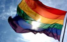 Fotografía de bandera de la diversidad sexual a contraluz.